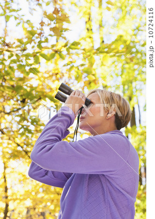 USA, New Jersey, Woman looking through binoculars in Autumn forest USA, New Jersey, Woman looking through binoculars in Autumn forest 10724116
