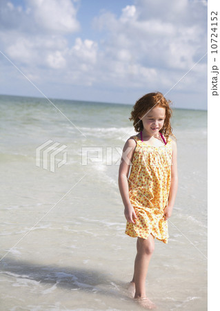 Girl walking through ocean surf Girl walking through ocean surf 10724152