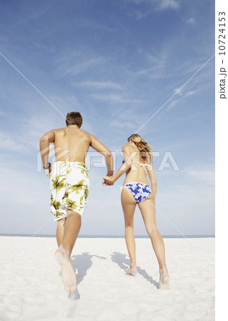 Young couple running on beach Young couple running on beach 10724153