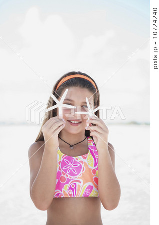 Girl on beach holding delicate starfish Girl on beach holding delicate starfish 10724240