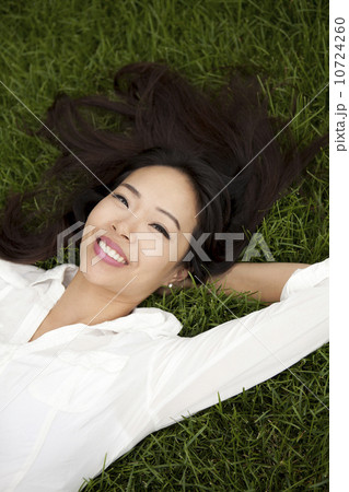 High angle view of smiling woman lying on lawn High angle view of smiling woman lying on lawn 10724260