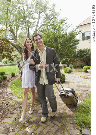 USA, New Jersey, Smiling couple with suitcase walking on footpath 10724298