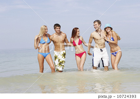 Friends wading in ocean 10724393