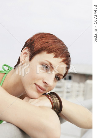 Young woman leaning on boardwalk railing 10724453