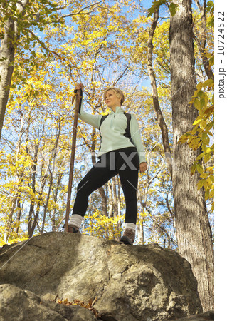 Female hiker resting on rock in forest 10724522