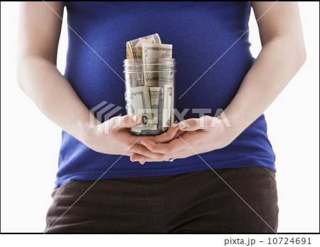 Studio Shot of mid section of pregnant woman holing jar with money 10724691