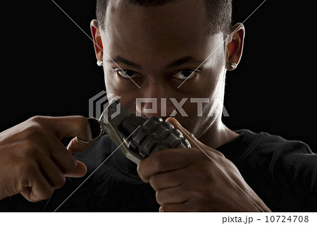 Studio portrait of young man holding grenade Studio portrait of young man holding grenade 10724708