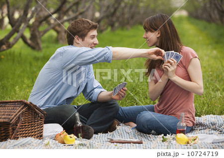USA, Utah, Provo, Young couple playing cards during picnic in orchard USA, Utah, Provo, Young couple playing cards during picnic in orchard 10724719