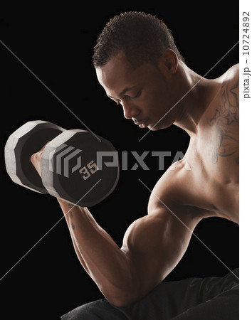 Studio shot of muscular man exercising with dumbbells Studio shot of muscular man exercising with dumbbells 10724892