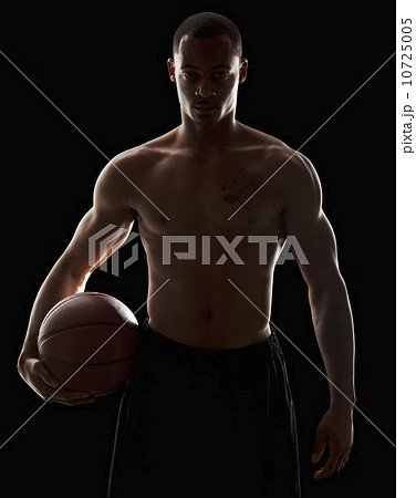 Studio portrait of shirtless man holding basketball Studio portrait of shirtless man holding basketball 10725005