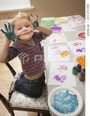 Boy (4-5) with paint covered hands 10725590