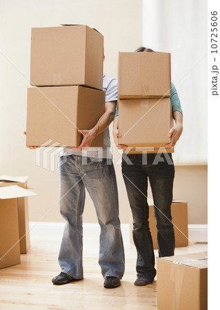 Mid adult couple carrying cardboard boxes 10725606