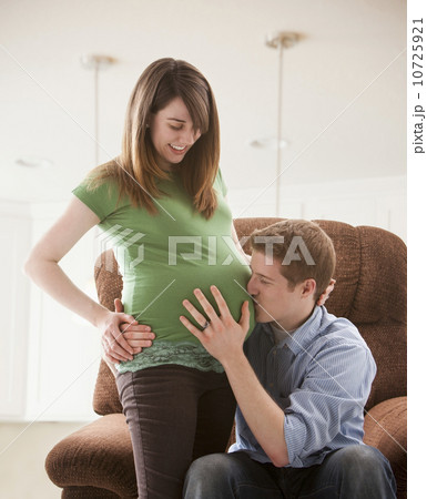 Man embracing pregnant woman, studio shot Man embracing pregnant woman, studio shot 10725921