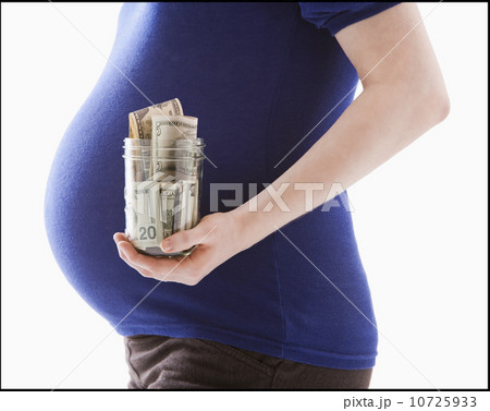 Studio Shot of mid section of pregnant woman holing jar with money Studio Shot of mid section of pregnant woman holing jar with money 10725933