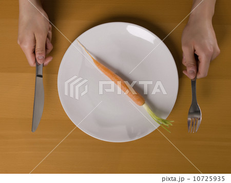 Single carrot on white plate 10725935