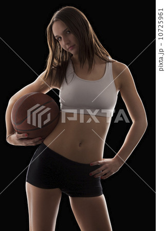 Studio portrait of young woman holding basketball Studio portrait of young woman holding basketball 10725961