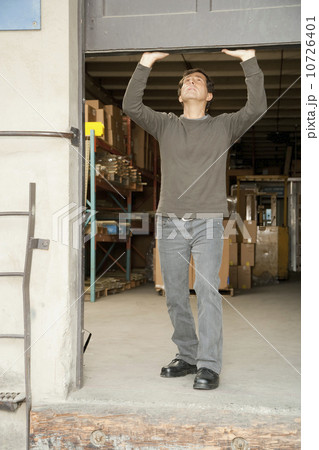 Man opening warehouse door Man opening warehouse door 10726401