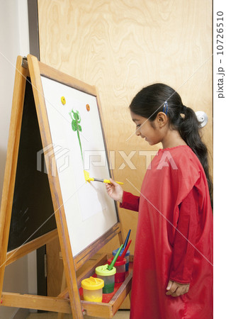 Young girl painting at an easel Young girl painting at an easel 10726510