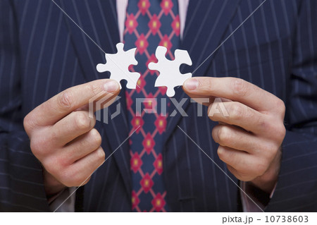 Man holding jigsaw puzzle pieces 10738603
