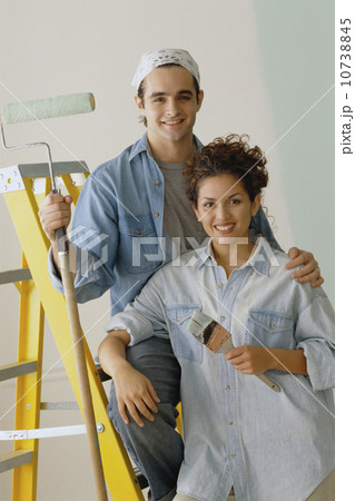 Happy couple painting the walls in their home Happy couple painting the walls in their home 10738845