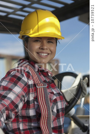 Portrait of female construction worker driving mechanical digger 10739521