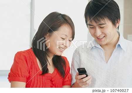 Couple looking at a cell phone Couple looking at a cell phone 10740027