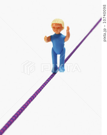 Studio shot of figurine balancing on tightrope 10740098