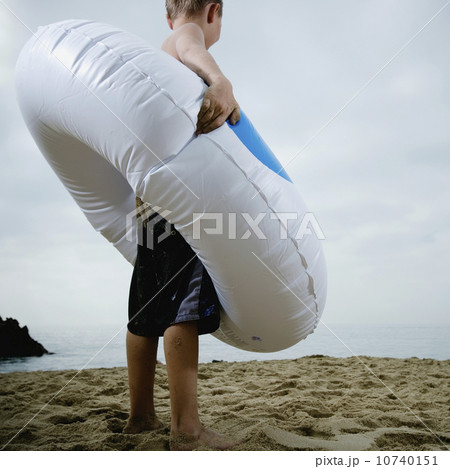 Young boy standing in an inflatable tube at the beach Young boy standing in an inflatable tube at the beach 10740151