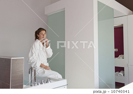 Woman in bathrobe sitting on tub 10740341