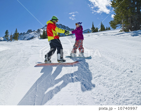 USA, Colorado, Telluride, Father and daughter (10-11) snowboarding  10740997