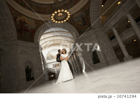 Bride and groom embracing under arch 10741294