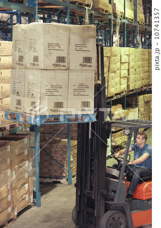 Man driving forklift in warehouse Man driving forklift in warehouse 10741357