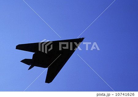Silhouette of military plane flying against blue sky, Holland Silhouette of military plane flying against blue sky, Holland 10741626