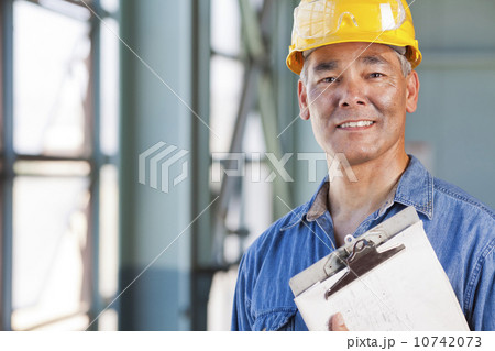 Portrait of man wearing hardhat holding clipboard Portrait of man wearing hardhat holding clipboard 10742073