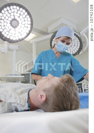 Surgeon preparing patient for surgery 10742108