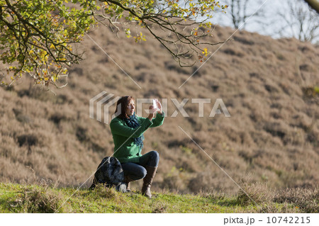 The Netherlands, Veluwezoom, Posbank, Hiker using camera in countryside The Netherlands, Veluwezoom, Posbank, Hiker using camera in countryside 10742215
