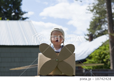 Baby boy (12-17 months) playing inside paper aeroplane made of cardboard box Baby boy (12-17 months) playing inside paper aeroplane made of cardboard box 10742428