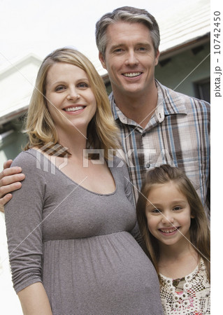 Pregnant mother, father and daughter (6-7) posing for portrait Pregnant mother, father and daughter (6-7) posing for portrait 10742450
