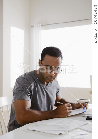Mature man using calculator 10742458