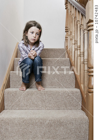 Girl (8-9) sitting on stairs 10742483