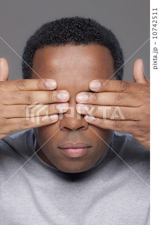 Studio shot of mid adult man covering eyes 10742511