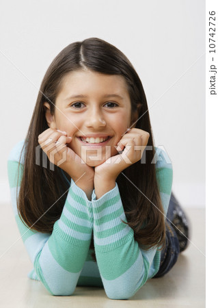 Studio portrait of girl (8-9) lying on floor 10742726
