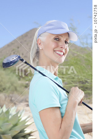 Portrait of mature woman holding golf club 10742758