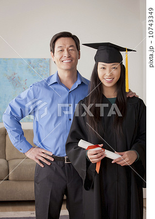 Portrait of young woman in graduation gown with mother and brother 10743349