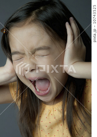 Studio portrait of girl (8-9) covering ears and screaming Studio portrait of girl (8-9) covering ears and screaming 10743525