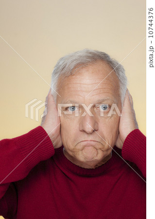 Studio shot of senior man covering ears 10744376