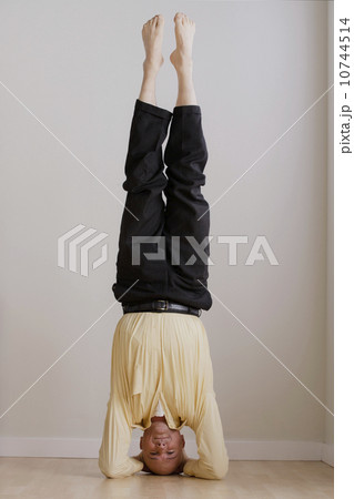 Mature businessman doing headstand 10744514