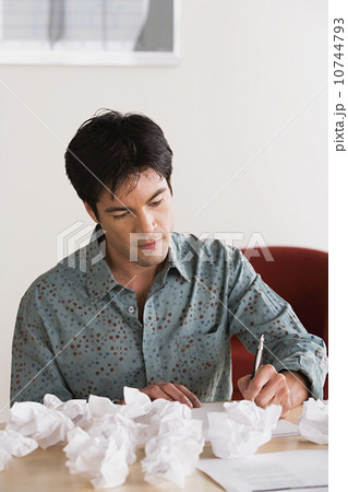 Businessman with crumpled paper balls 10744793