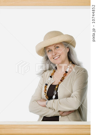 Studio portrait of mature woman behind picture frame Studio portrait of mature woman behind picture frame 10744852