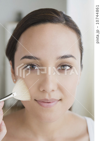 Woman applying make-up 10744861